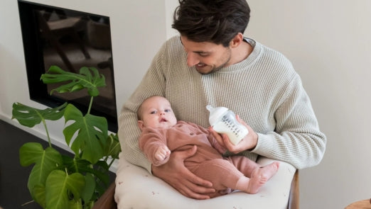 papa geeft baby flesje